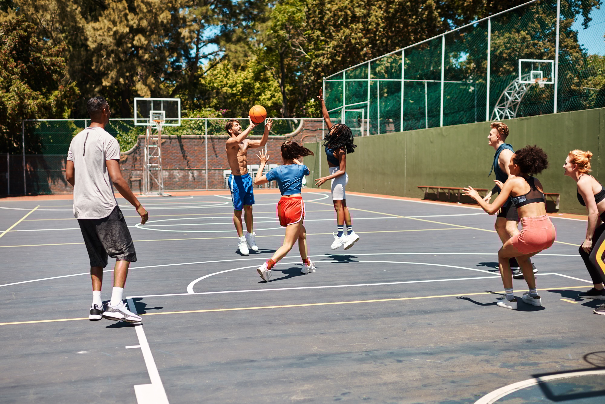 Court is in session. Shot of a group of sporty young people playing basketball on a sports court.